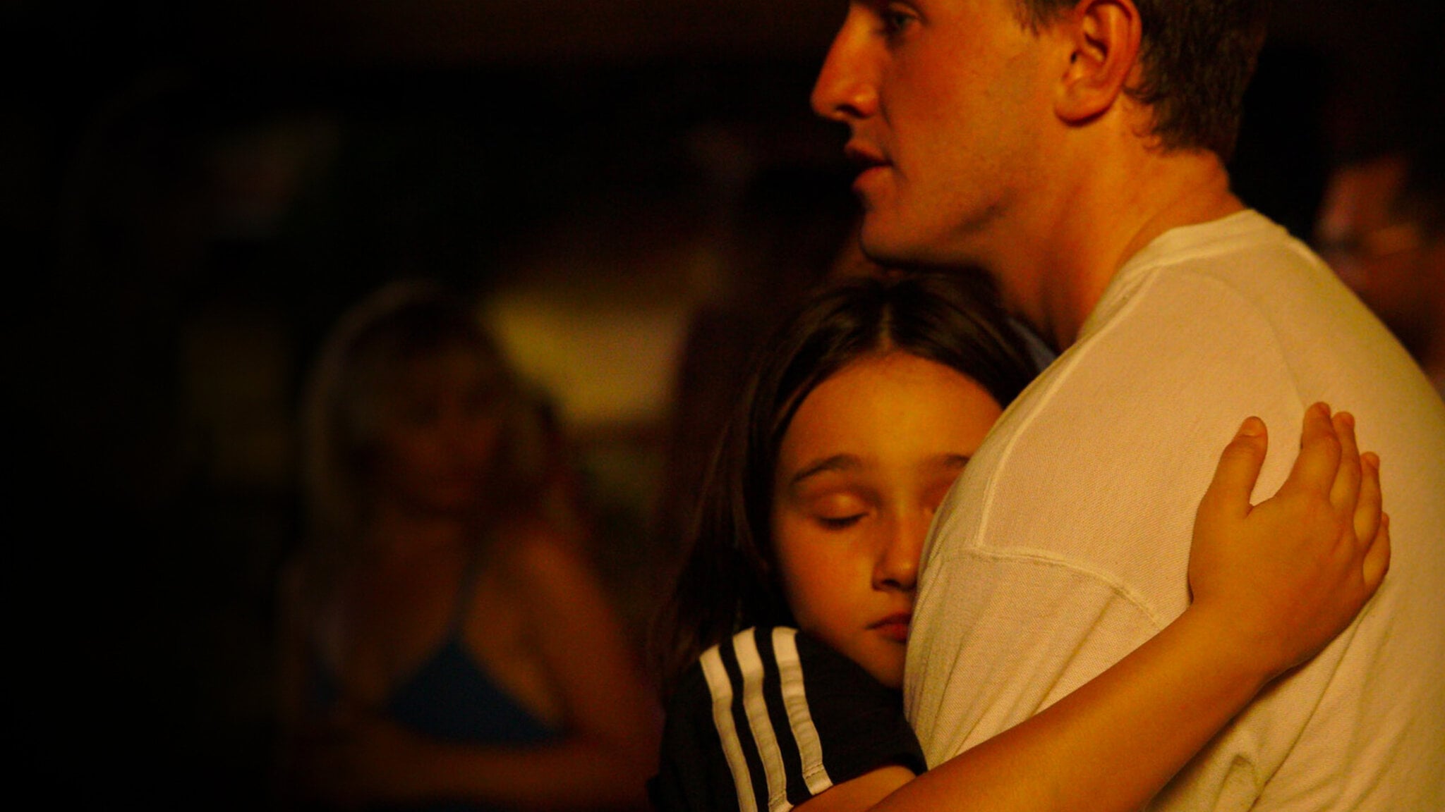 A still from Perfect Days (2023) showing Hirayama lying on a futon at night, reading quietly under a desk lamp, reflecting the film’s focus on stillness, routine and everyday life.